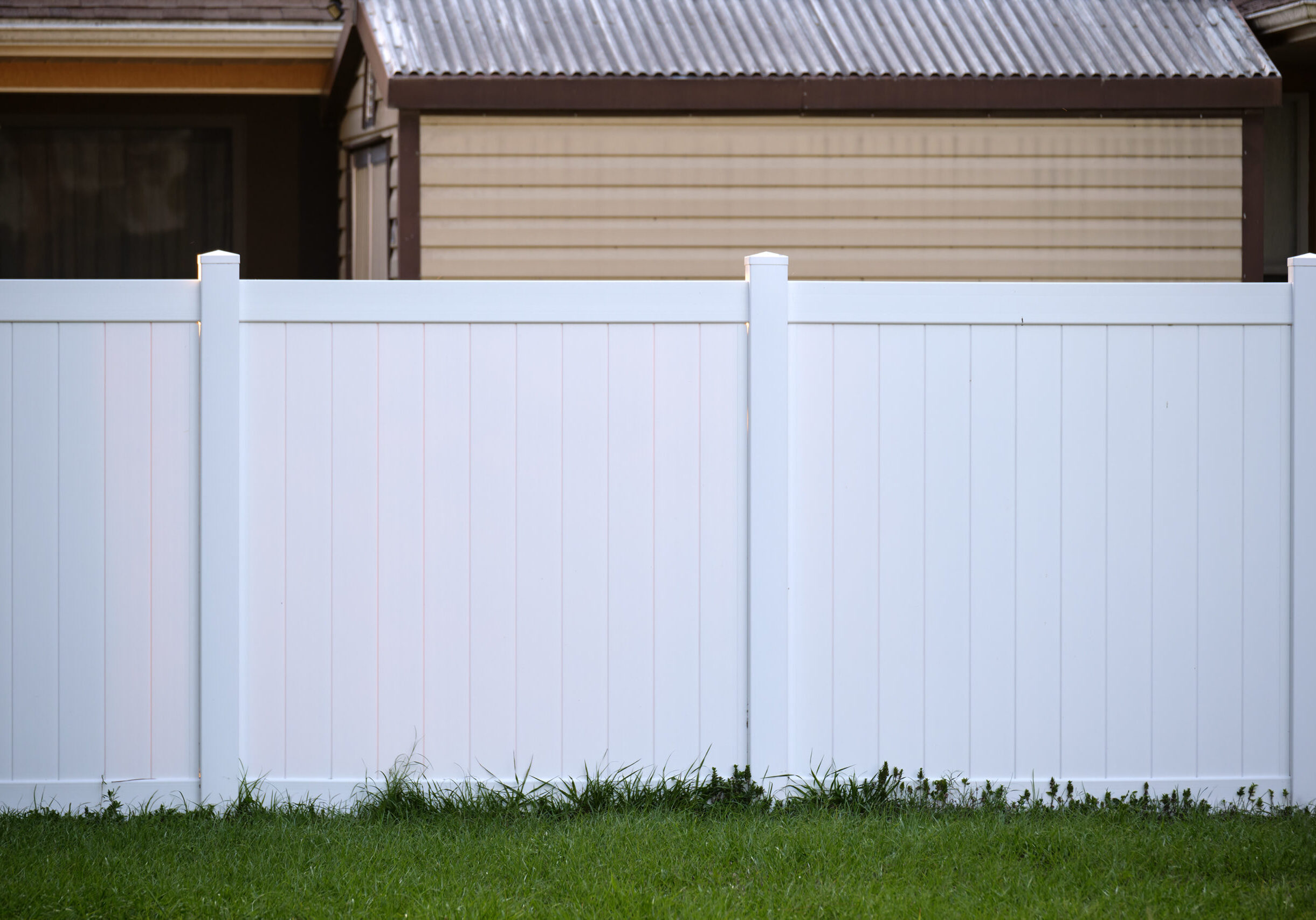 White plastic fence for back yard protection and privacy.