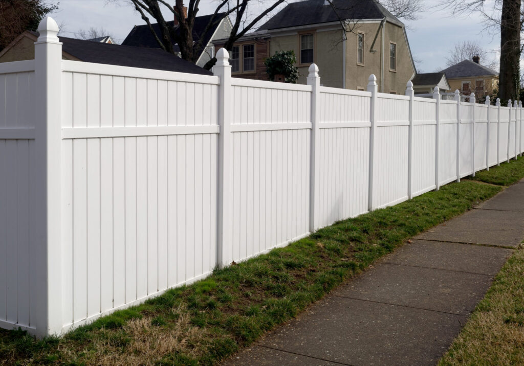 White vinyl fence in residential neighborhood.